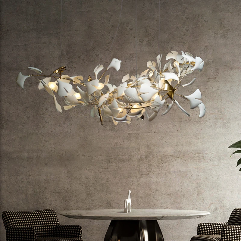 A luxury dining room with a modern design featuring a white chandelier hanging over a table.
