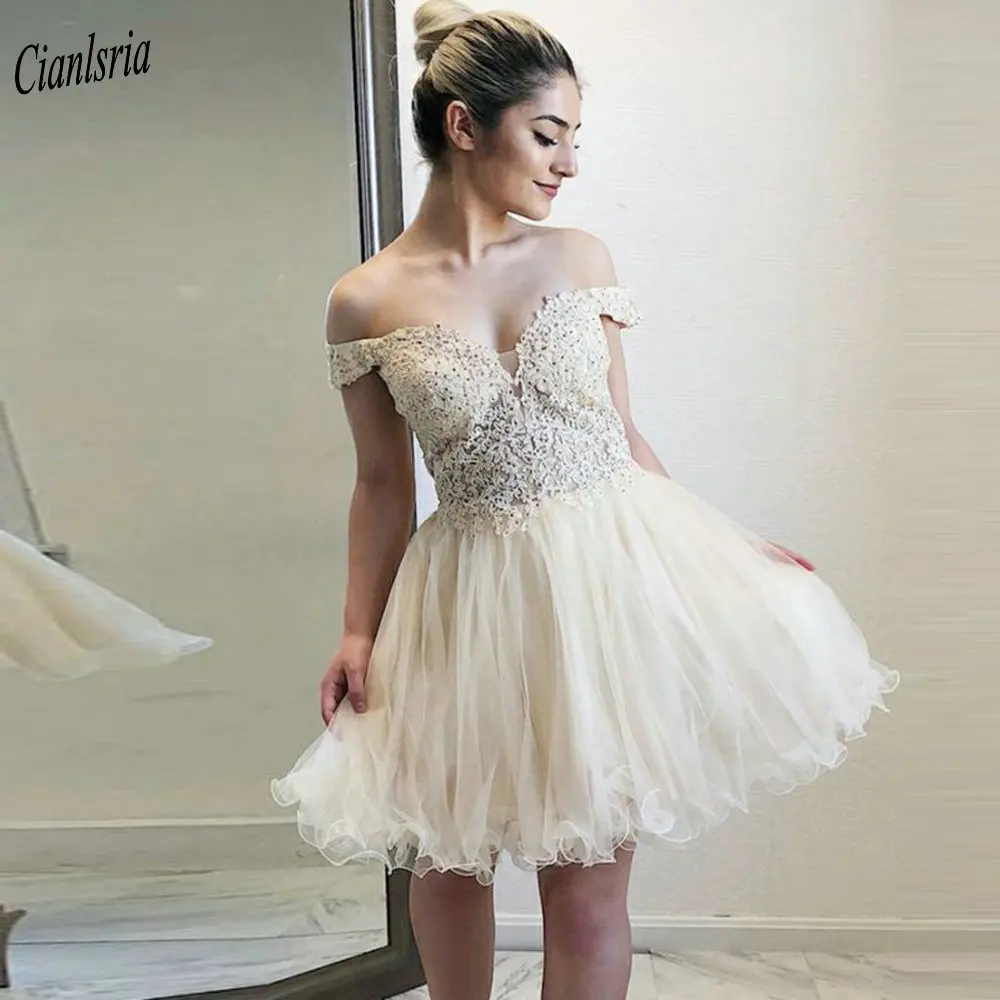 

Бежевое мини-платье с открытыми плечами и стразами