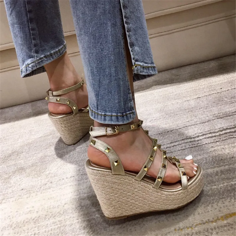 Женские босоножки на танкетке золотого цвета высоком каблуке с заклепками