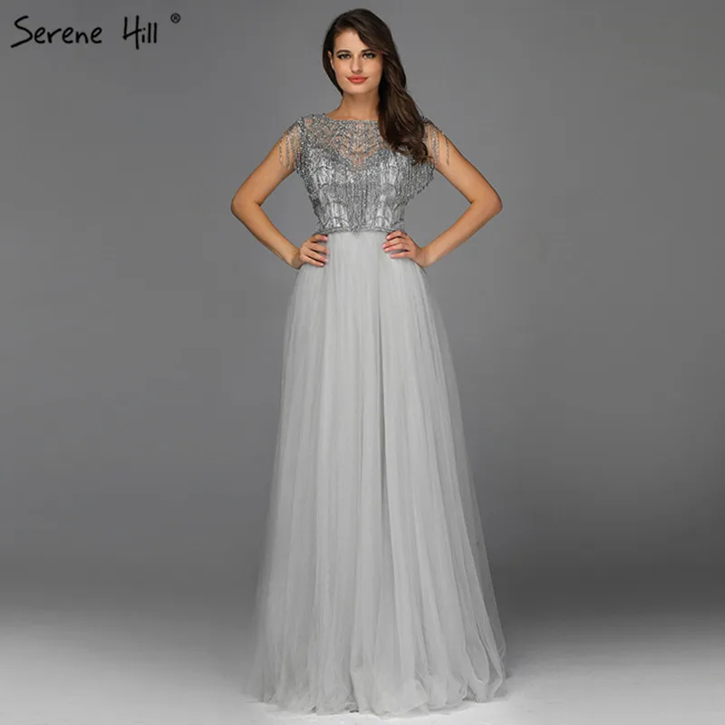 Серое вечернее платье с круглым вырезом и кисточками украшенное бусинами