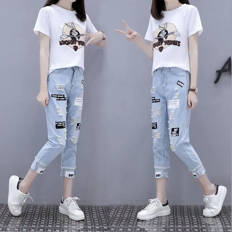 Женский комплект из футболки с принтом и джинсов перфорацией летний сезон 2023