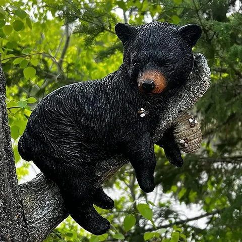 Забавная фигурка в виде черного медведя в дереве