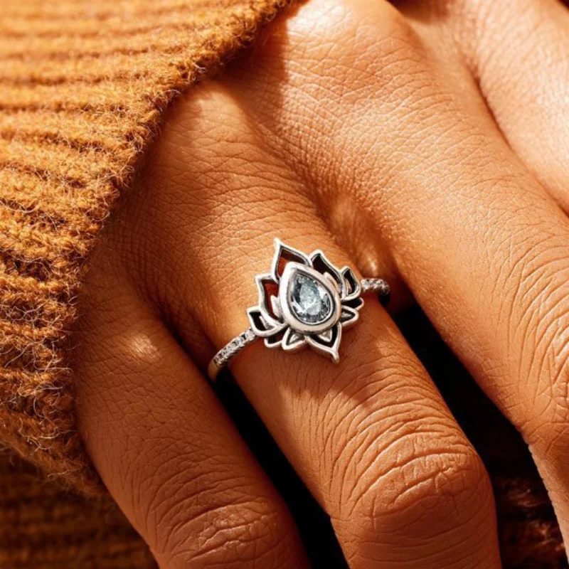 

Геометрическое кольцо в виде капли воды с цветком из нового сплава с перекрестной границей