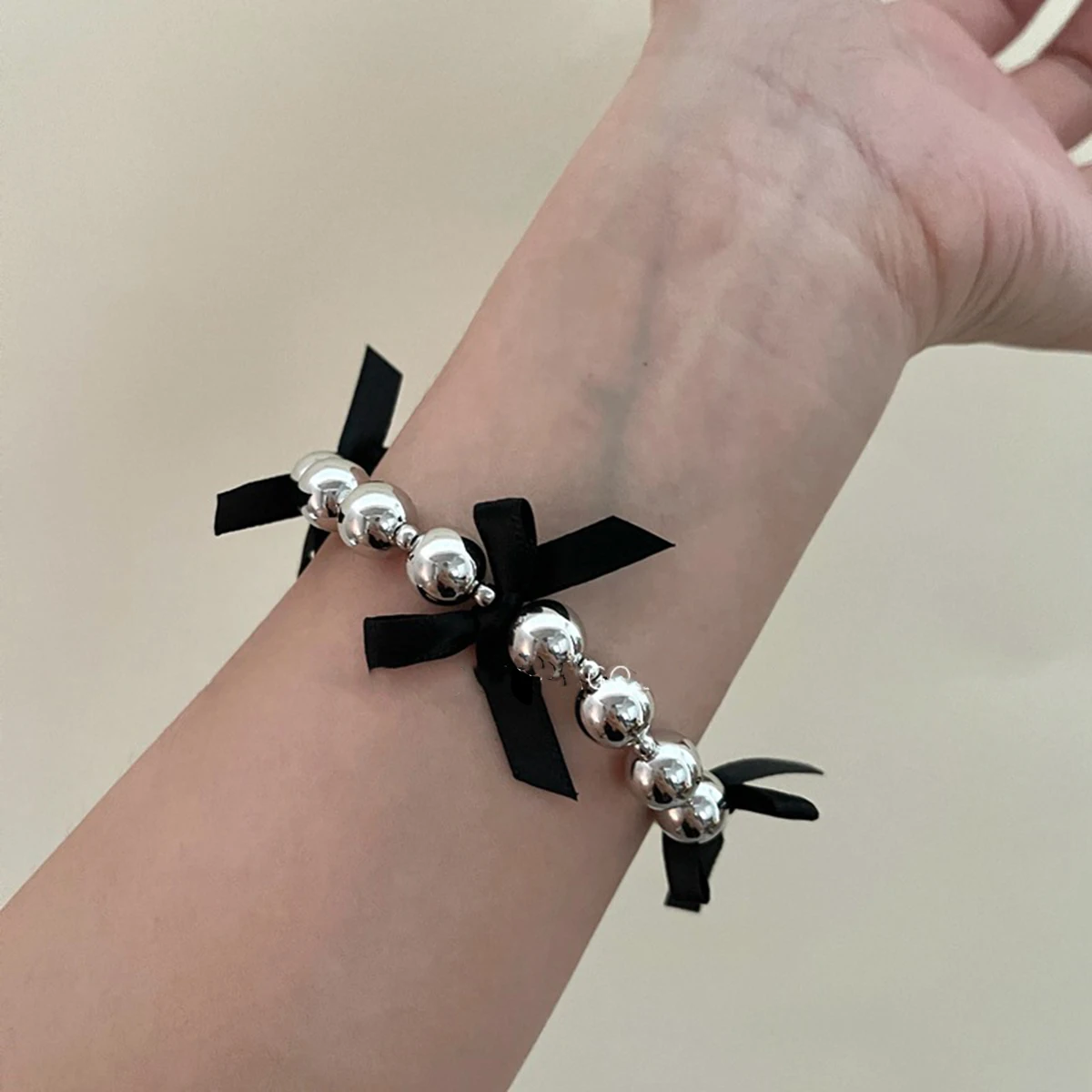 Женский браслет с искусственным жемчугом серебристый блестящий черным бантом