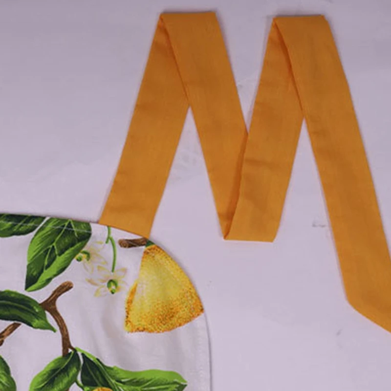 Кухонный фартук с зелеными листьями и лимоном карманами без рукавов висящий на