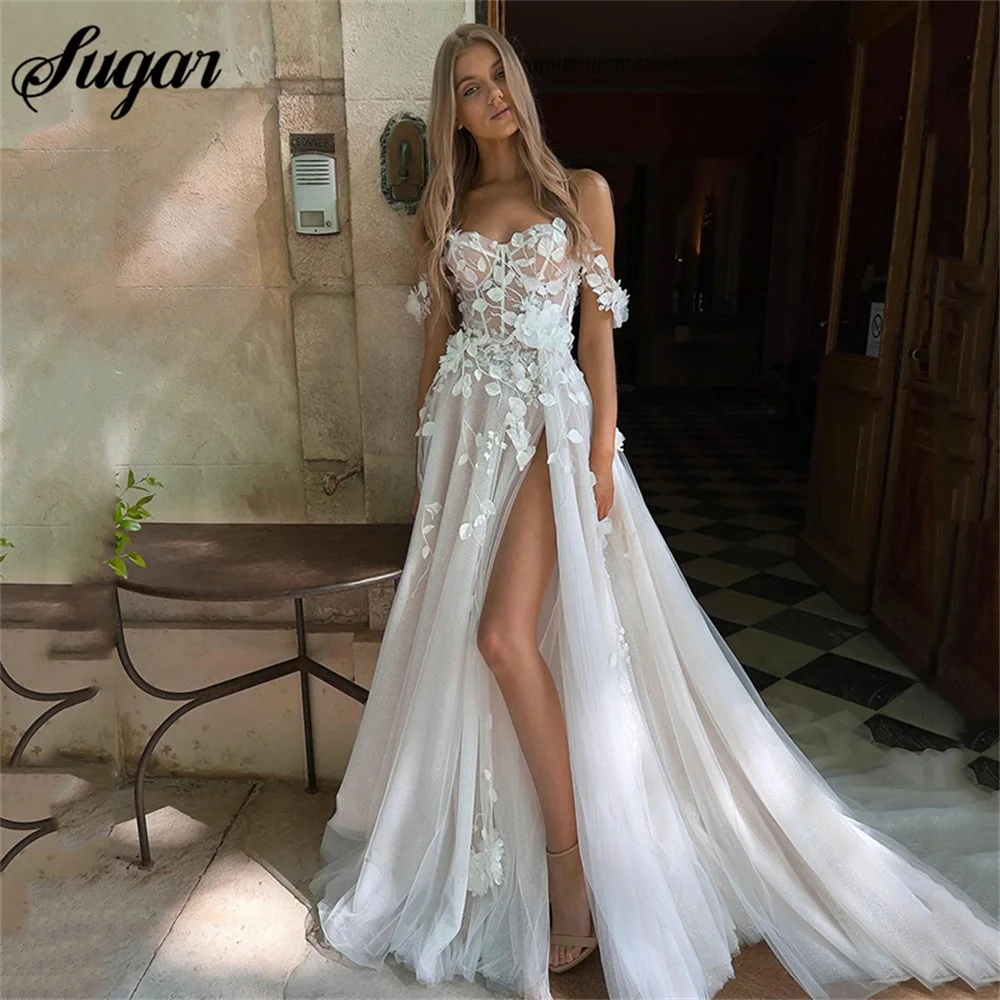 

Свадебное платье с объемными цветами, открытыми плечами и разрезом по бокам