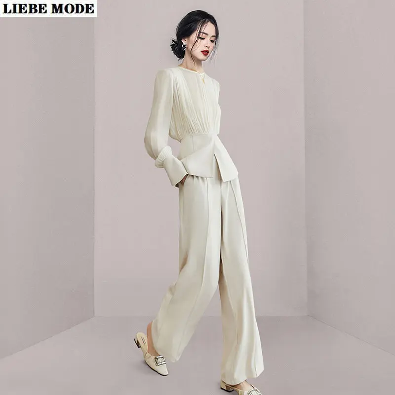 

Женская блузка с длинным рукавом и брюки с широкими штанинами