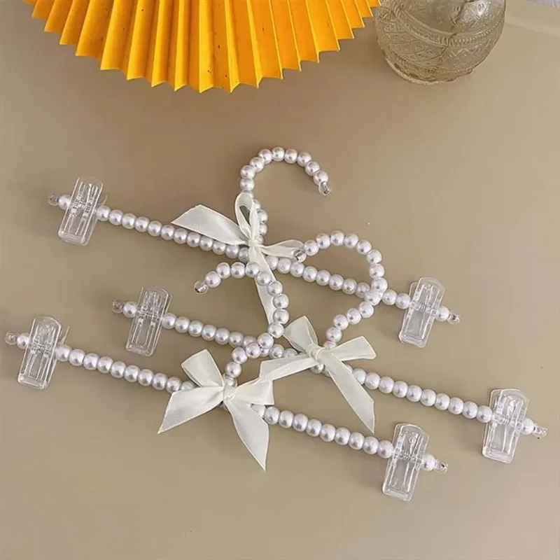 Фото Набор из 5 практичных многофункциональных пластиковых вешалок для детской одежды с жемчужным декором, органайзер для хранения и организации детской одежды дома №1