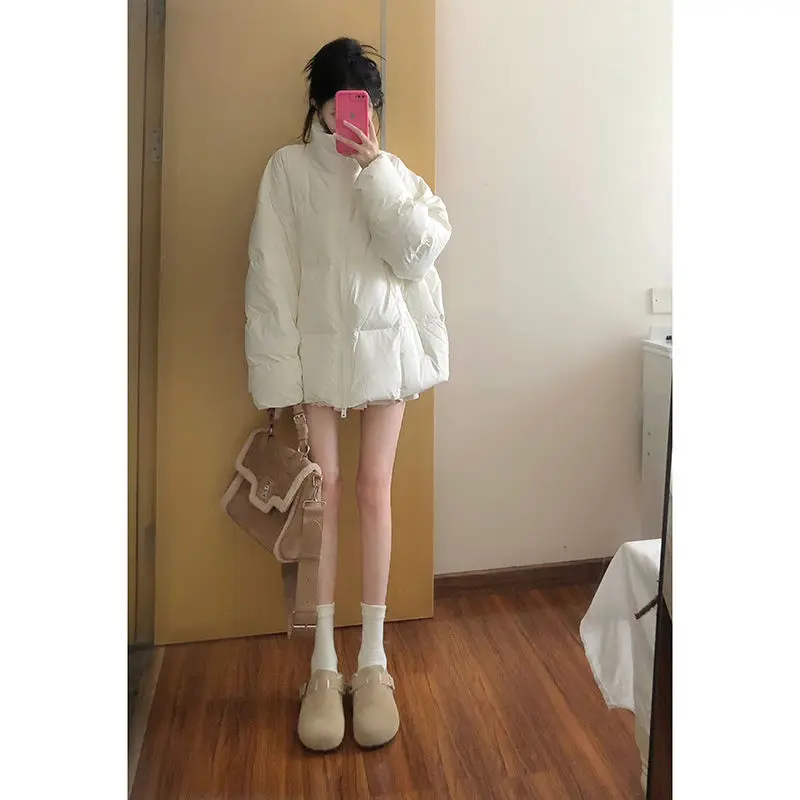 Утолщенное теплое пуховое пальто средней длины со свободным воротником-стойкой.