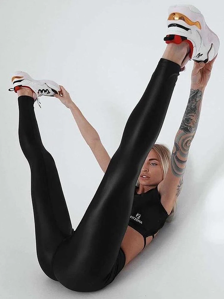 Спортивная девушка в черном топе и спортивных штанах на белом фоне | Премиум Фото