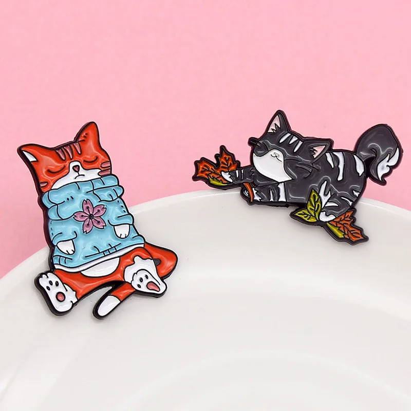 

SALeeee The orange cat wears a blue sweater brooch, the gray cat stretches its waist a lot, the cartoon cute lazy cat brooch