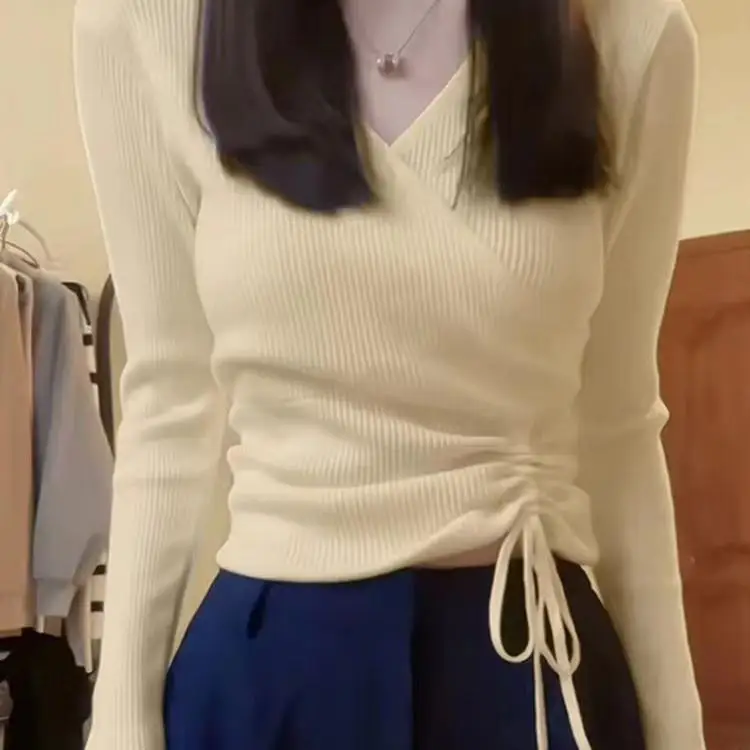 Белая трикотажная рубашка с v-образным вырезом и длинными рукавами на плечах