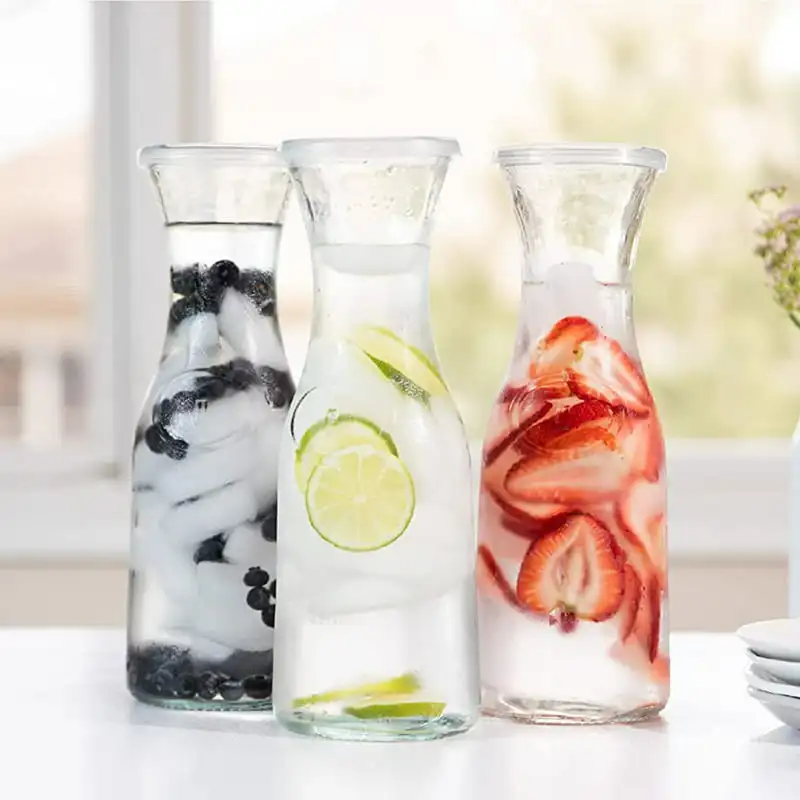 

3 Pack Luxurious, Clear Glass Carafe Kitchen Set with Twist-Off Lids - 35 Oz Capacity, Ideal for Storing Juices and Beverages.