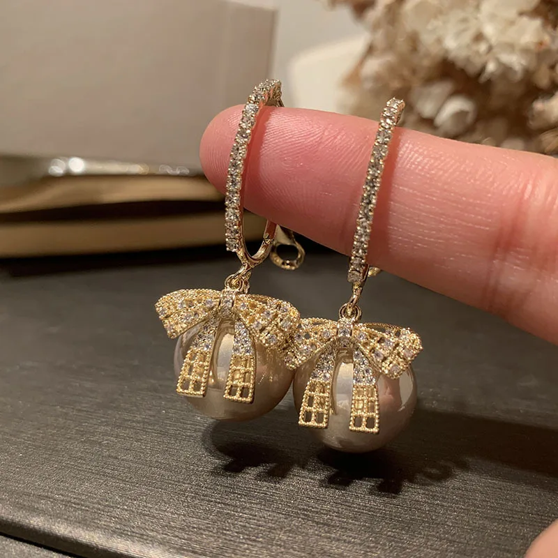 

Hollow bow earrings sweet and small S925 silver needle temperament lady net red coffee color pearl tassel earrings