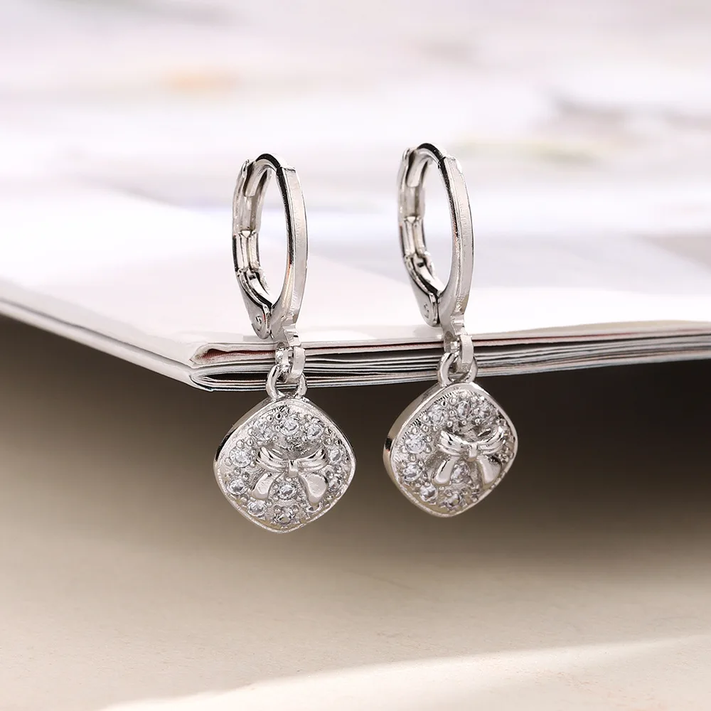 Женские квадратные серьги-кольца с ромбовидным бантом и фианитами