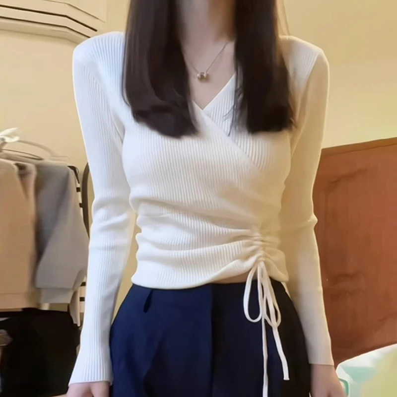 Белая трикотажная рубашка с v-образным вырезом и длинными рукавами на плечах