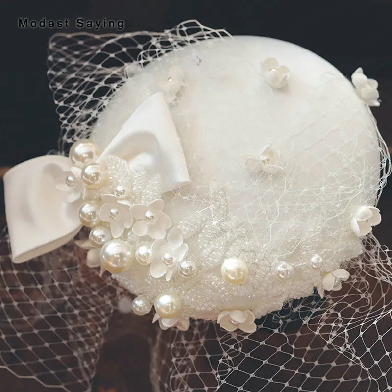 

Ivory Bridal Felt Hats 2022 with Veils Bow Wedding Headwear with Hearpin Floral Pearls Topper Mesh Birdcage Headpiece Accessory