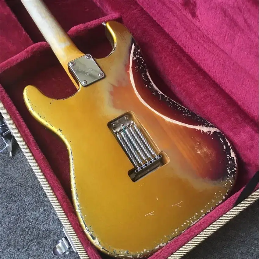 Новая 6-струнная реликевая гитара имеет набор золотистых оттенков заката.