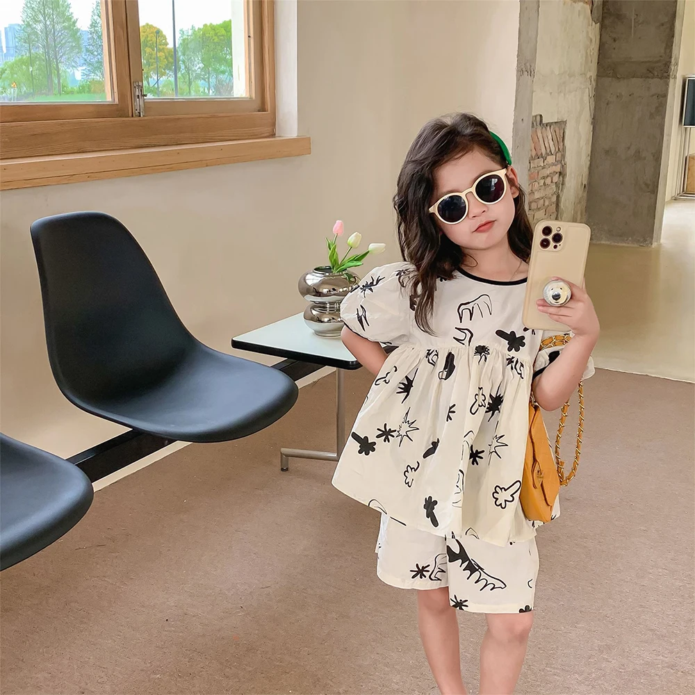 

Милый детский костюм с коротким рукавом для девочек, Новинка лета 2023, корейские детские черно-белые шорты с граффити, комплект из двух предметов, одежда