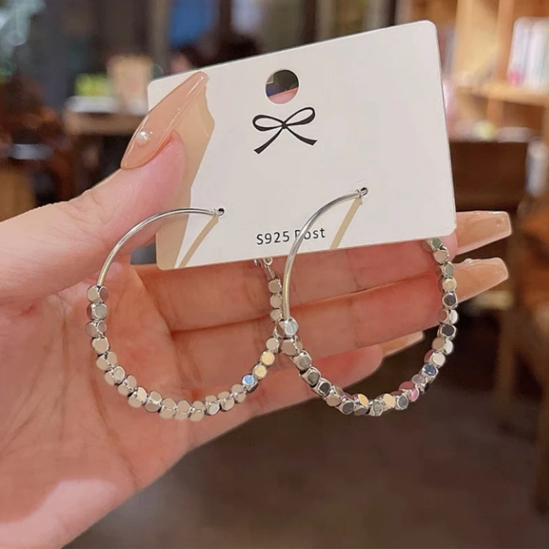 

Большие серьги-кольца, круглые серьги-гвоздики, легкие серьги-кольца с крошечными бусинами, увеличенные круглые серьги