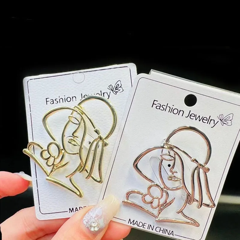 Женская металлическая брошь в форме головы