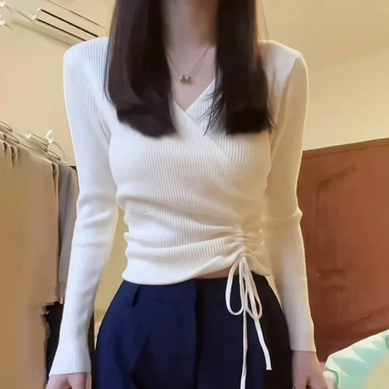 Белая трикотажная рубашка с v-образным вырезом и длинными рукавами на плечах