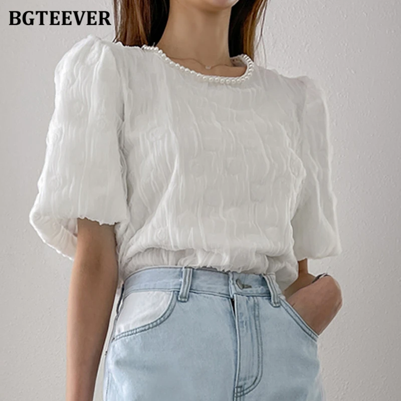 

Женская блузка с буффами на рукавах, круглым вырезом и жемчугом