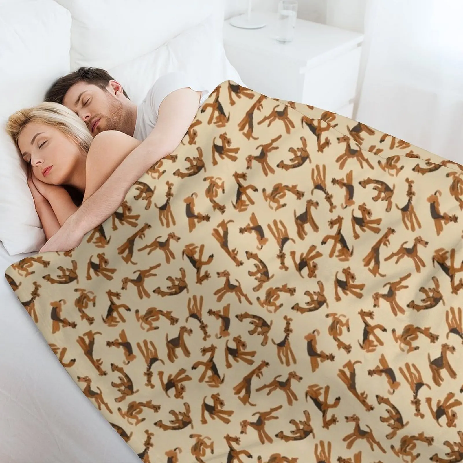 Роман из Airedales на брошенном одеяле