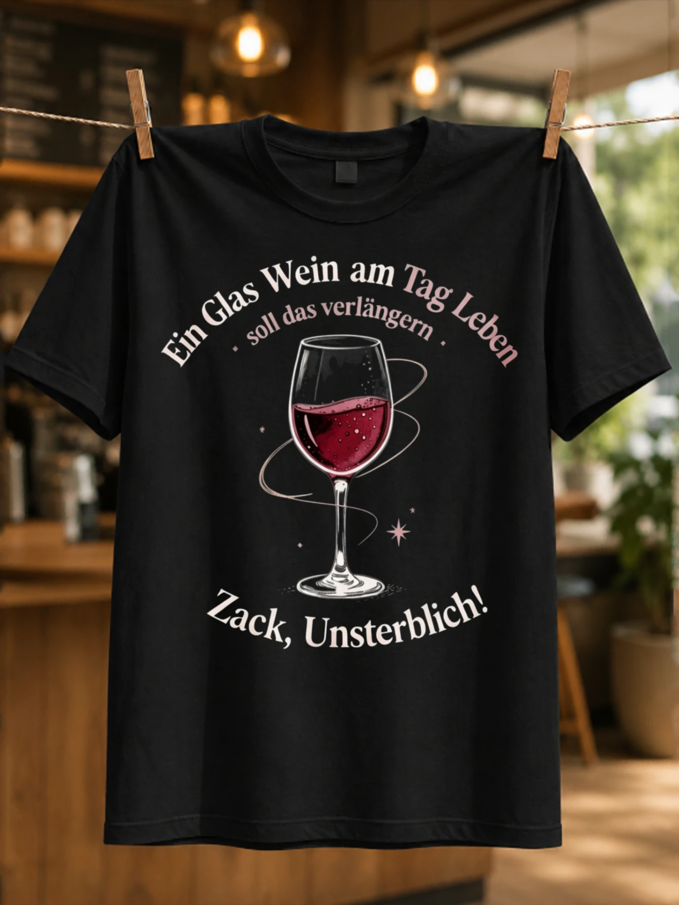 Фото Футболка унисекс с принтом «Ein Glas Wein Am Tag Zack Unsterblich»: сверкающий бокал для красного вина и яркие розовые надписи. №1