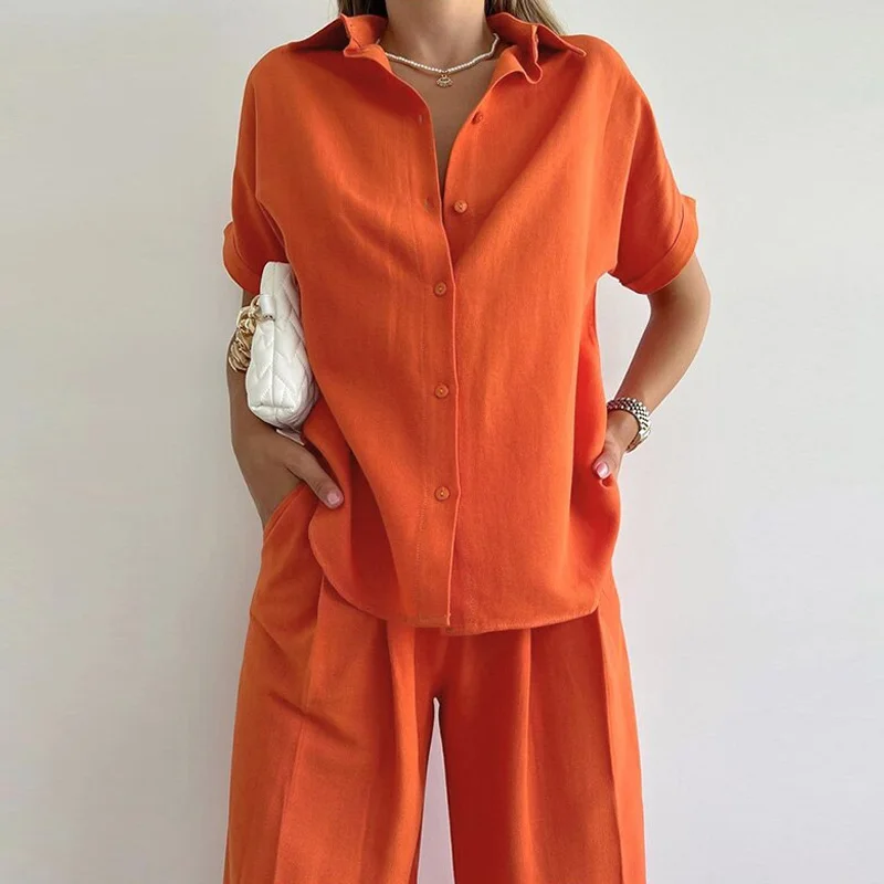 

Женская блузка с коротким рукавом и брюки с широкими штанинами