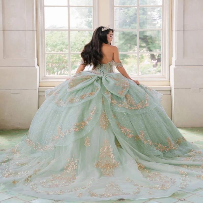 Фото Светло-зеленое блестящее бальное платье для Quinceanera с золотыми аппликациями, кружевом, бисером, кристаллами, бантом, тюлем, корсетом и открытыми плечами, для Sweet 16 №4