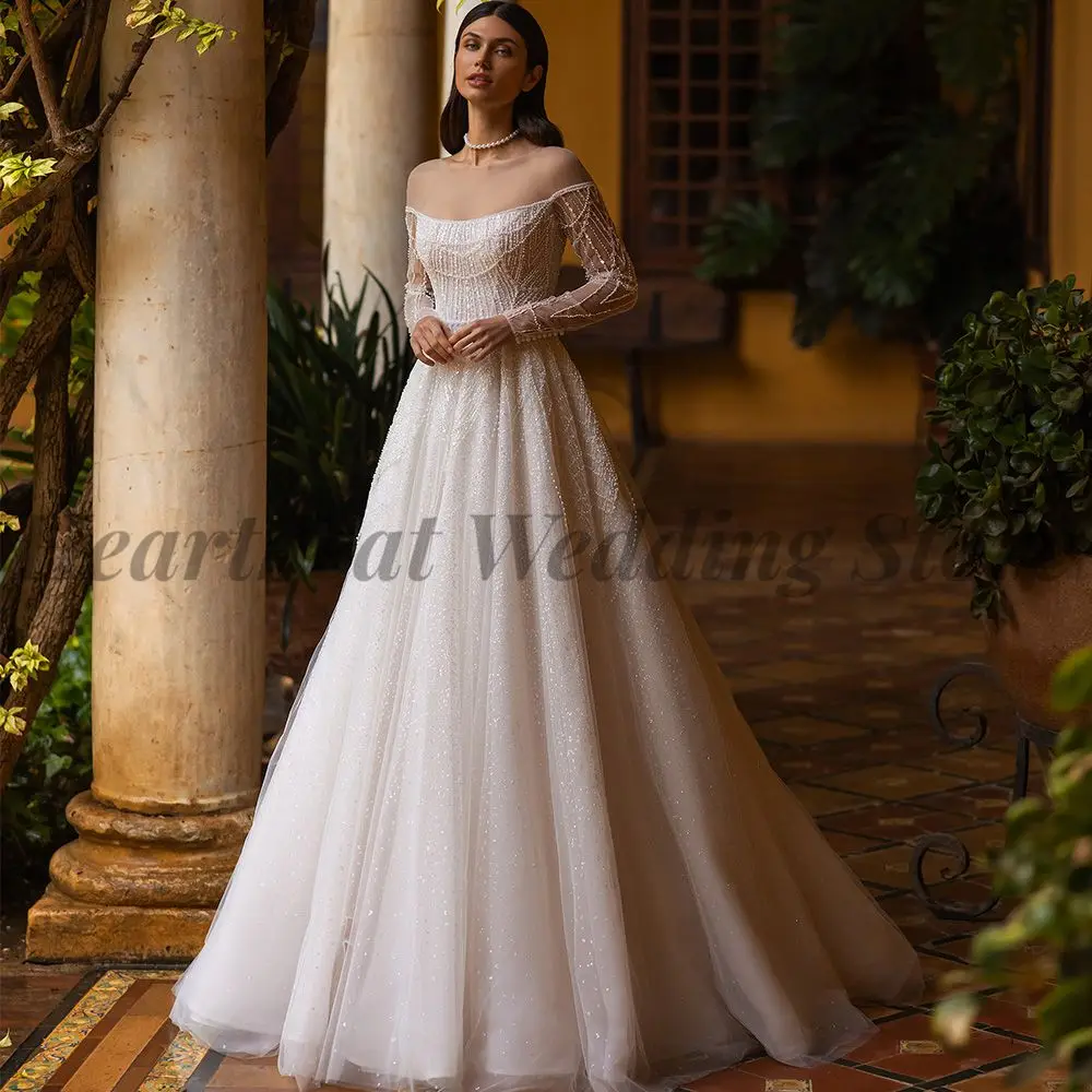

A-Line Long Sleeve Wedding Dress with Boat Neck Court Train Button Back and Applique Sequins Beads Pearls for Brides 2023