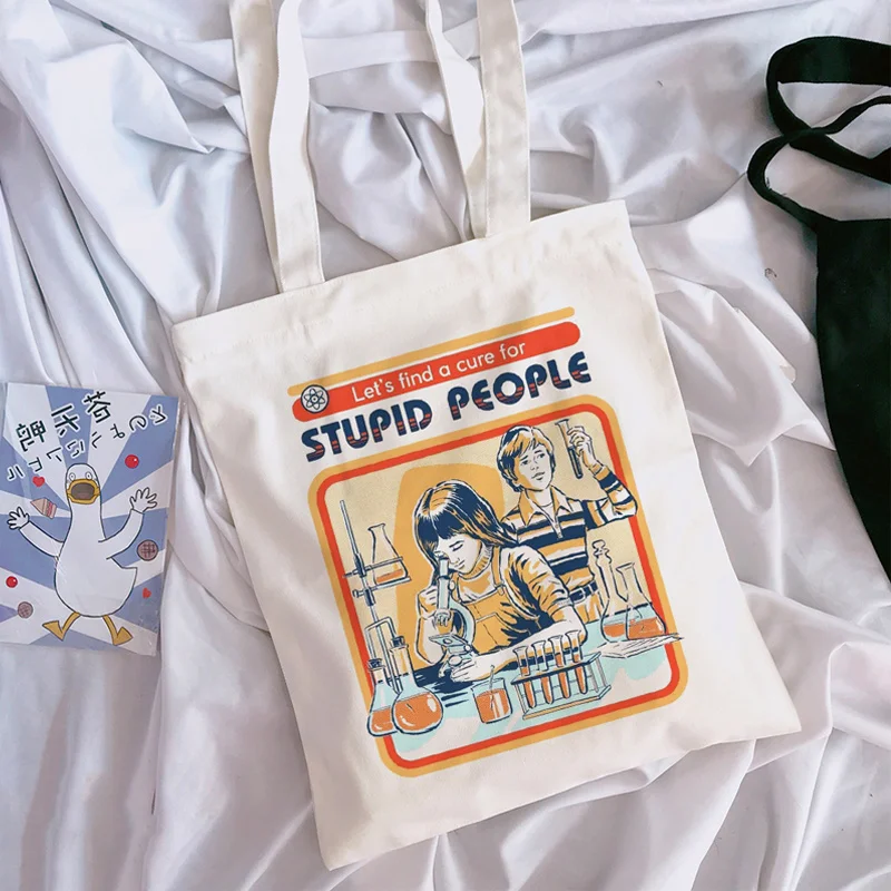 

Let's find a cure for stupid people Devil Letter Print Women Canvas Large Capacity Vintage Harajuku Cartoon Casual Shoulder Bag