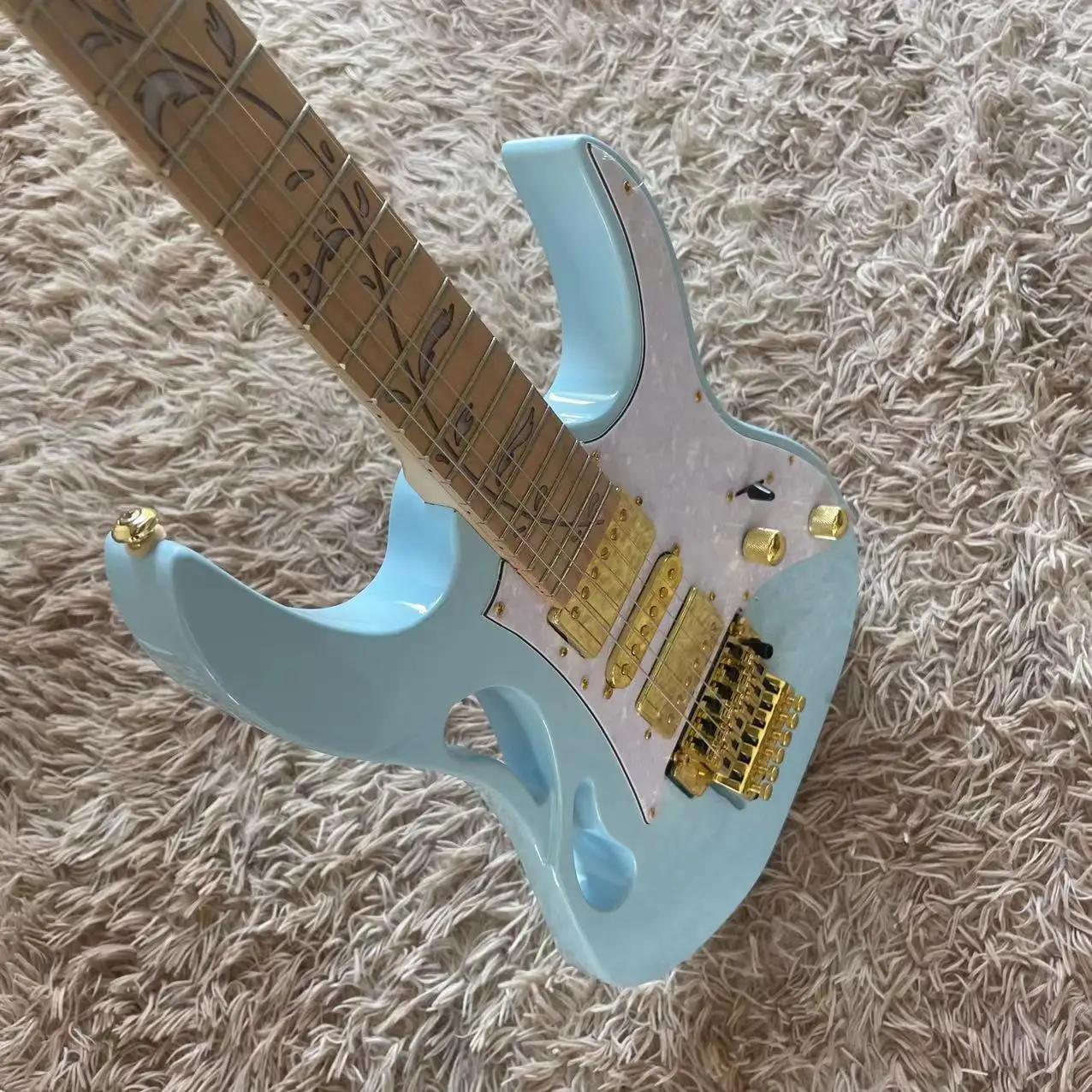 

6-string electric guitar, light blue body, maple fingerboard, double single and double pickups, white pearl guard, tremolo pull