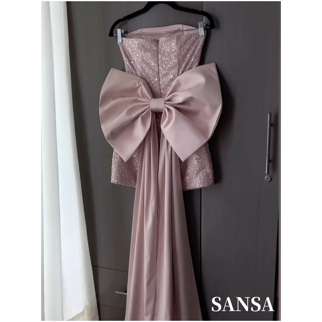 Фото Индивидуальное мини-платье Sansa без бретелек, розовое, из однотонного атласа, с блестящими стразами, драпированной юбкой и большим бантом на спине, для коктейльных вечеринок №1