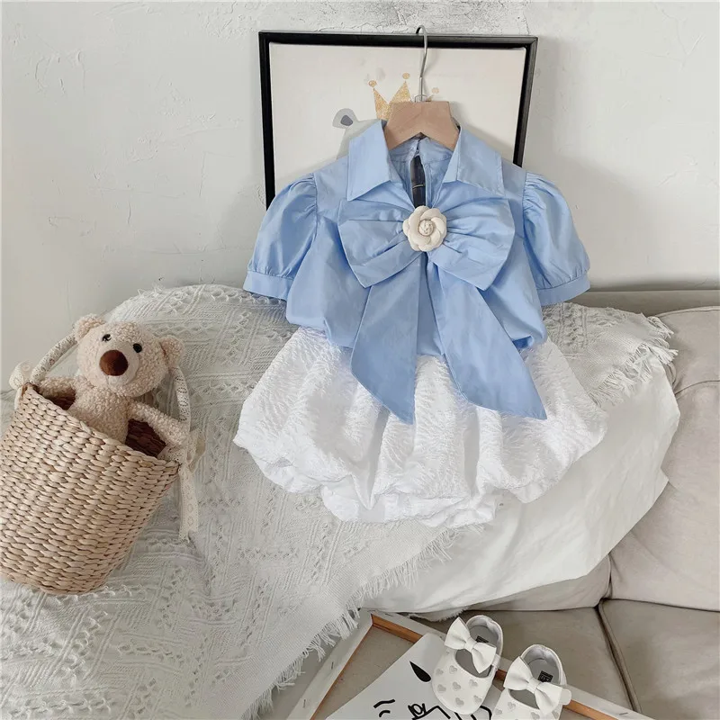 

Новинка 2022, летний костюм для девочек, короткая Однотонная рубашка с бантом + свободные шорты из пены с цветами, модная повседневная детская ...