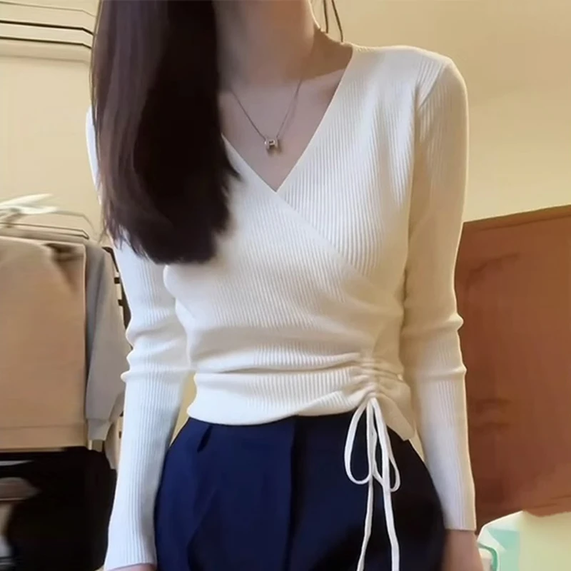 Белая трикотажная рубашка с v-образным вырезом и длинными рукавами на плечах