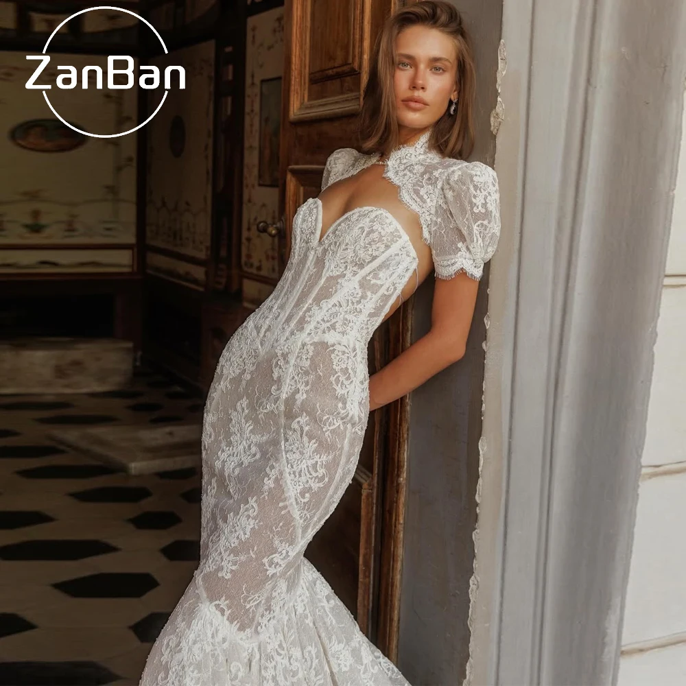 Фото Свадебные платья ZanBan: Элегантные кружевные платья с высоким воротником, короткими рукавами и открытой спиной, модель «Русалка», белые, 2026 год №4
