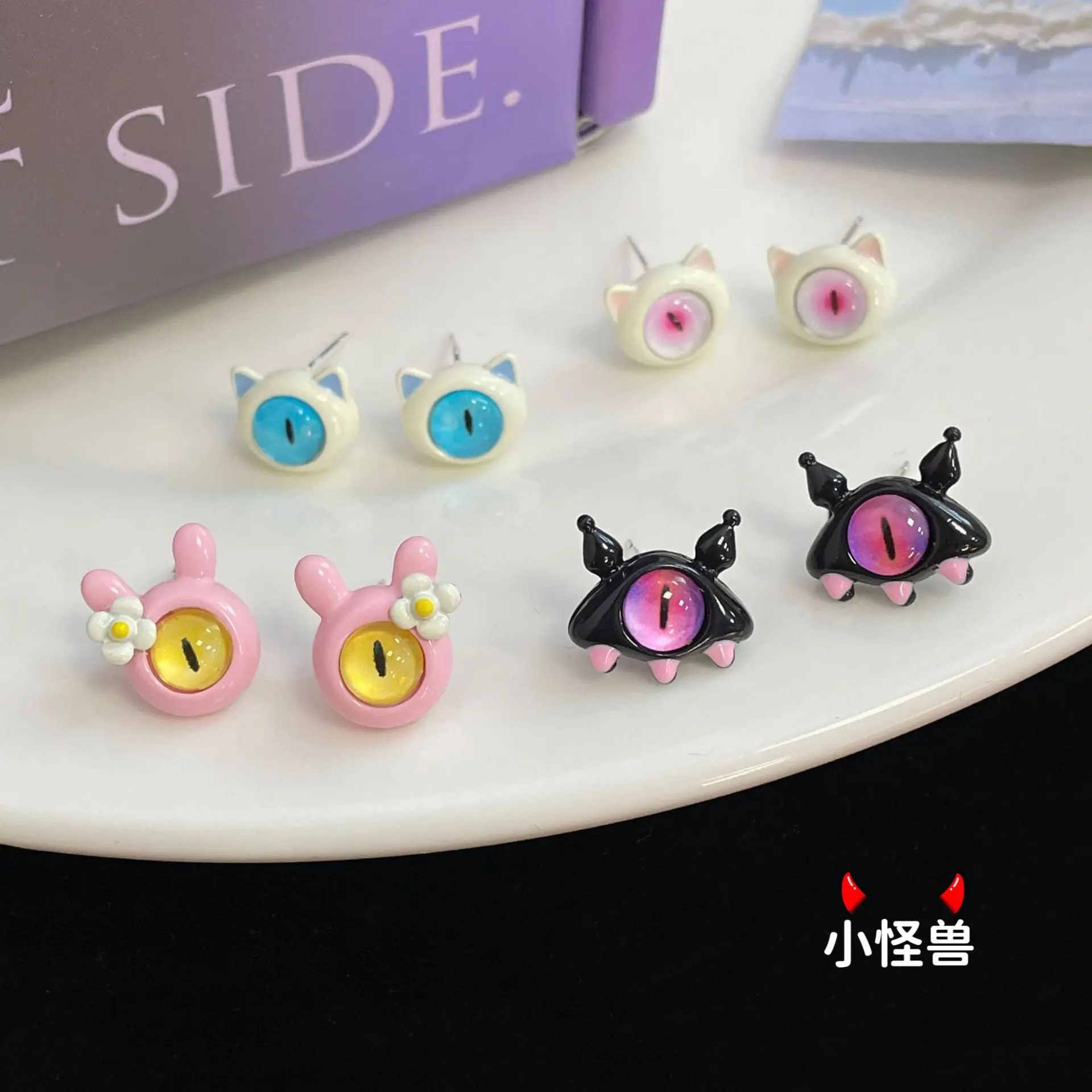 

Fun and funny little monster earrings, cute and niche personality cartoon little devil Halloween cat's eye stone silver needle e