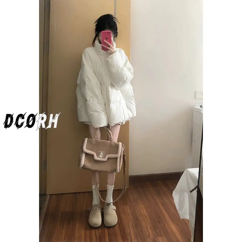 Утолщенное теплое пуховое пальто средней длины со свободным воротником-стойкой.