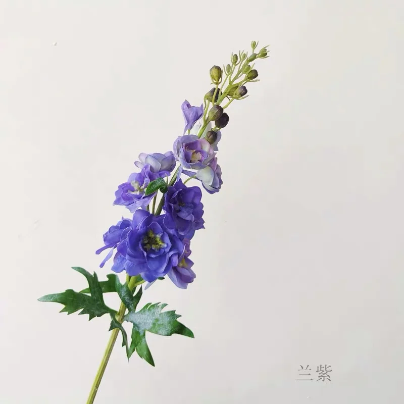 

Обеденный стол с искусственными цветами и растениями украшен декорированием Delphinium для дома и сада