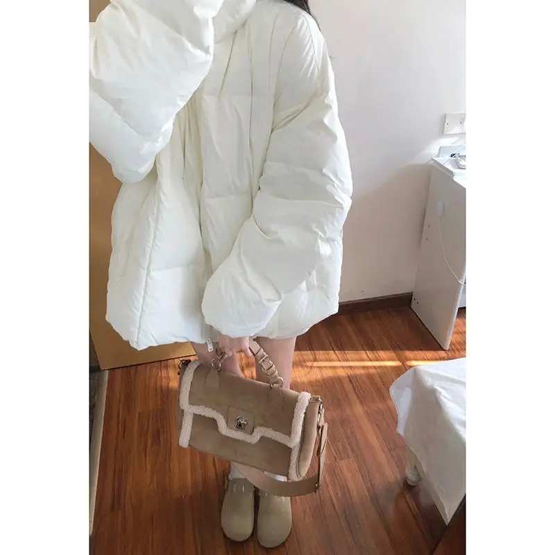 Утолщенное теплое пуховое пальто средней длины со свободным воротником-стойкой.