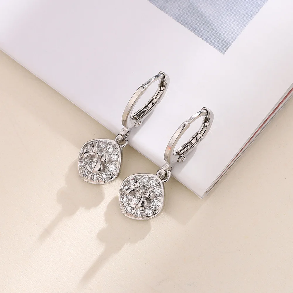 Женские квадратные серьги-кольца с ромбовидным бантом и фианитами