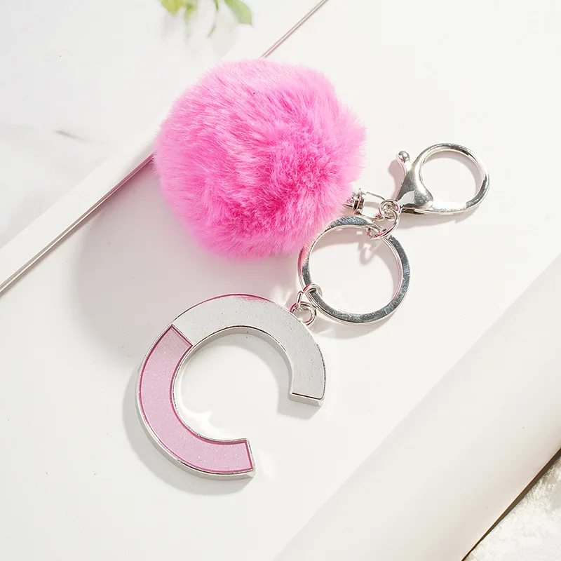 Брелок из сплава серебристого цвета с розовыми двухцветными буквами CDBEA помпоном