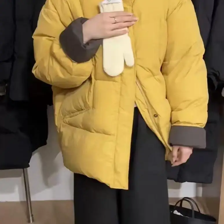 Женский пуховик средней длины контрастного цвета с воротником-стойкой зима 2024