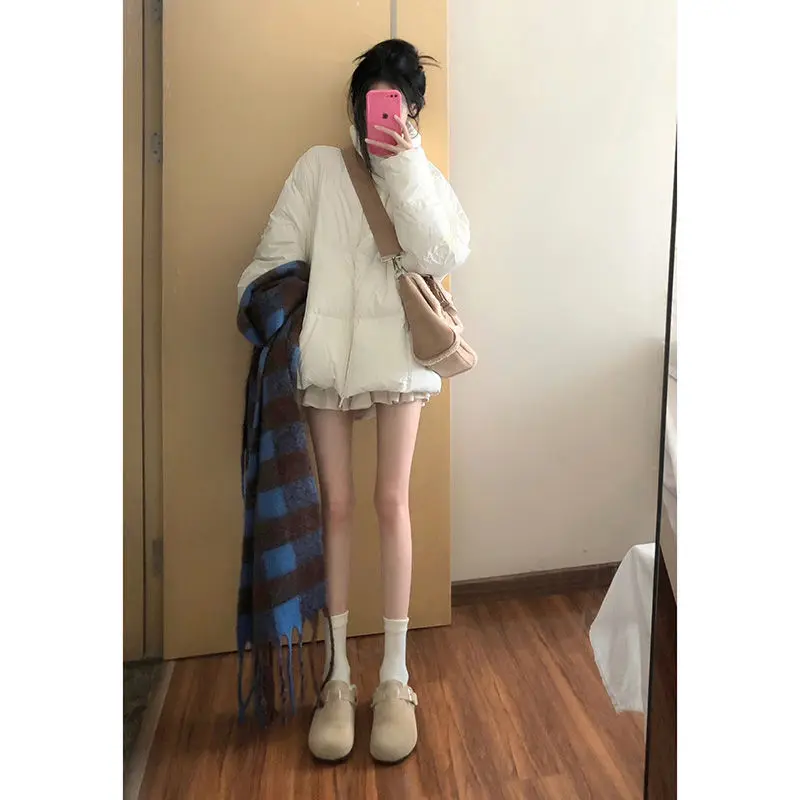 Утолщенное теплое пуховое пальто средней длины со свободным воротником-стойкой.