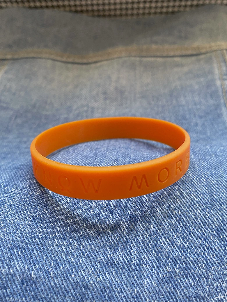 Настраиваемые оранжевые круглые браслеты из ПВХ-силикона с множеством цветов и выдавленным логотипом в большом количестве для клубных спортивных мероприятий.